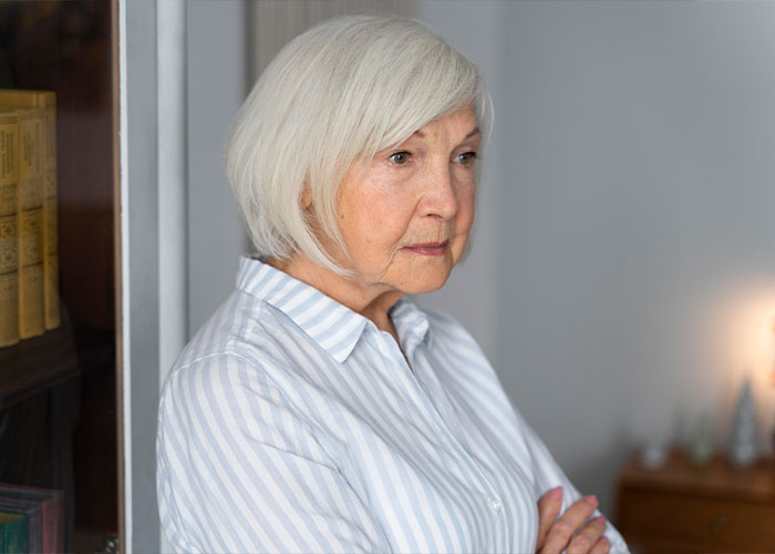Elderly woman with gray hair in a striped shirt looking thoughtful, reflecting on unserious reasons for boycotting brands.