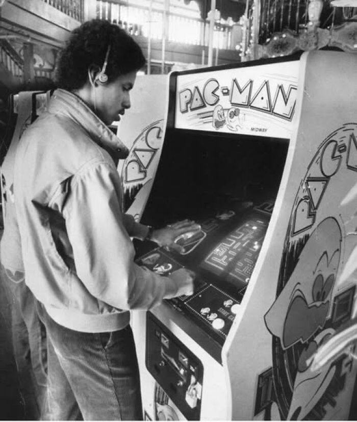 A man plays a vintage Pac-Man arcade machine, capturing a lesser-known historical moment in gaming.