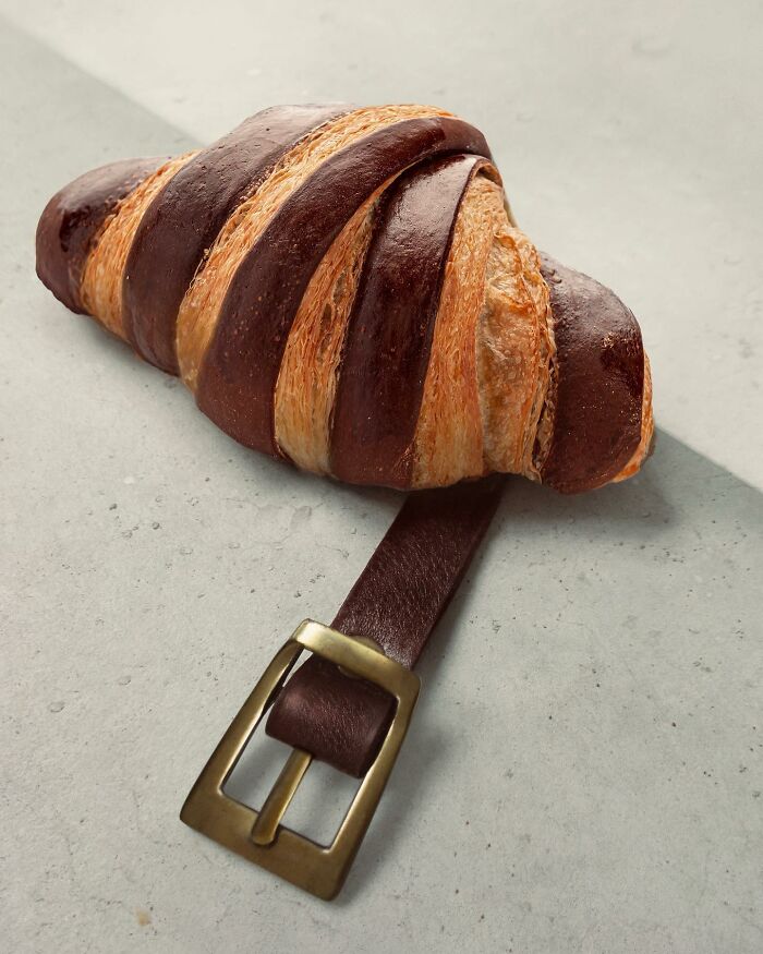 A croissant fused with a leather belt, showcasing the art of illusion by Dudi Ben Simon.
