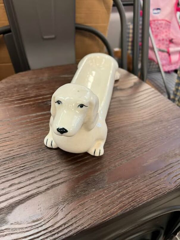 Porcelain dachshund figurine found while thrifting, placed on a wooden table.