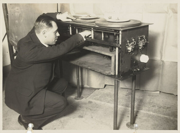 A man examines a vintage, revolutionary invention in a workshop setting.