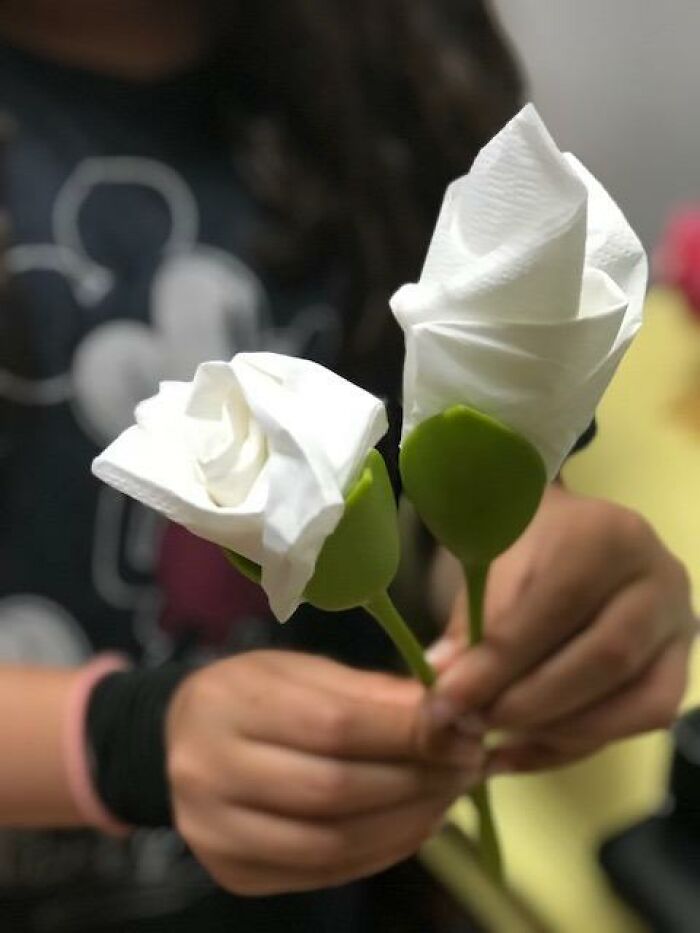 Hands holding napkin roses, a creative product from Peleg Design Shop.