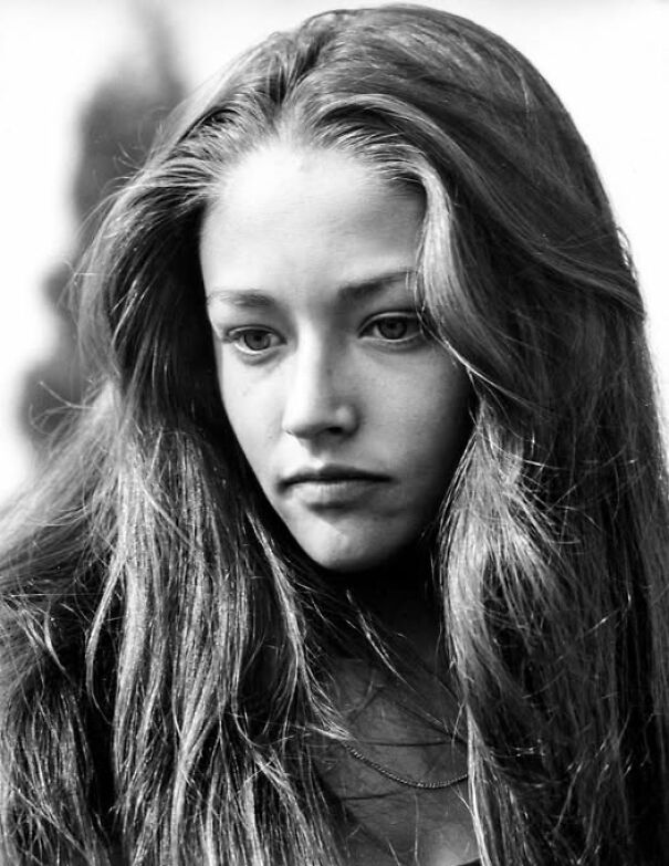 Young woman with long hair in a historical black and white photo, offering a glimpse into the past.