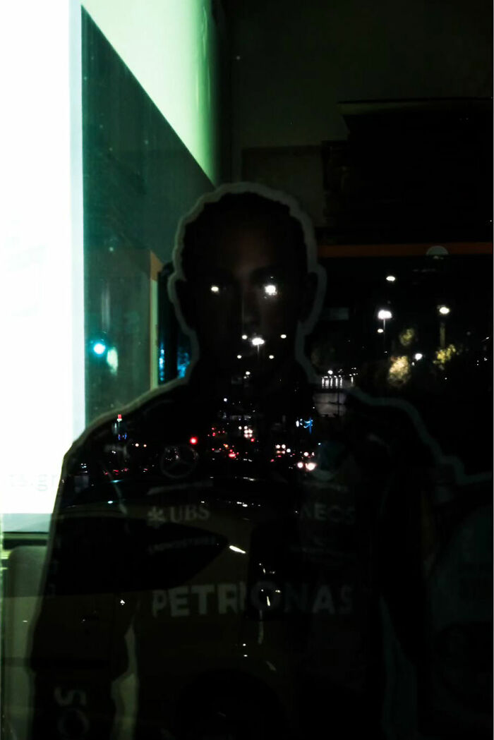 Silhouette of a person with street lights reflected, showcasing street life's raw beauty.