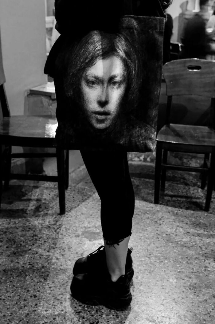 Street life photography captures a woman's face on a bag, held by someone standing indoors.