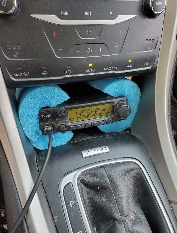 Car radio humorously cushioned with pool noodle in the console.