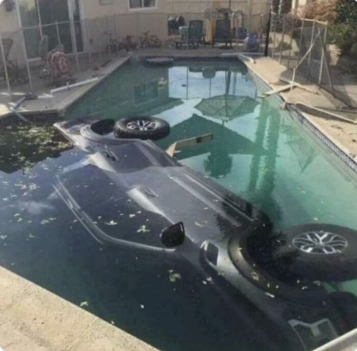 Car upside down in a swimming pool, showcasing a random and funny scene without needing context.