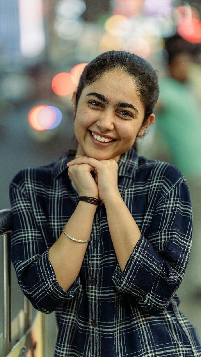Smiling woman in a plaid shirt, captured beautifully by an Indian photographer.