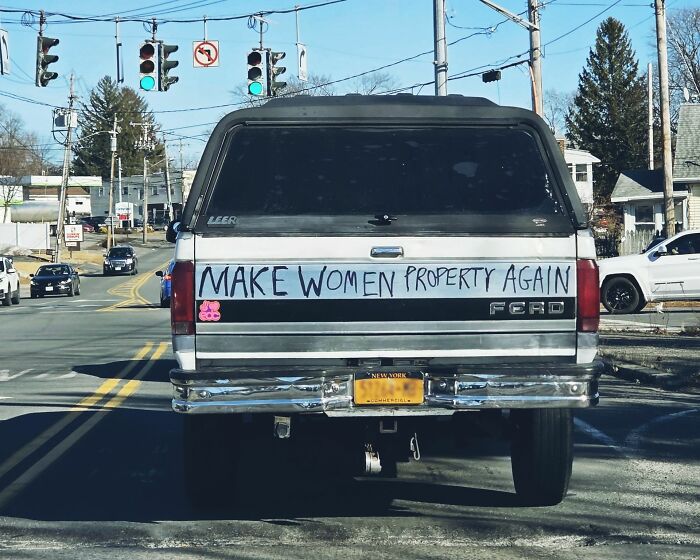 Camioneta con mensaje polémico en la parte trasera, una opinión escandalosa en una calle transitada.