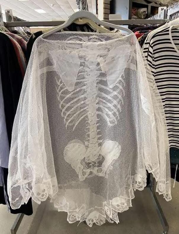 Sheer lace top with skeleton pattern found while thrifting, displayed on a hanger in a store.