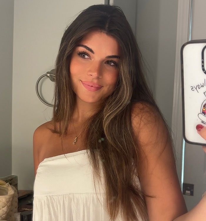 Young woman takes a selfie, smiling softly, related to viral romantic note from pilot. Young woman takes a selfie, smiling softly, related to viral romantic note from pilot.