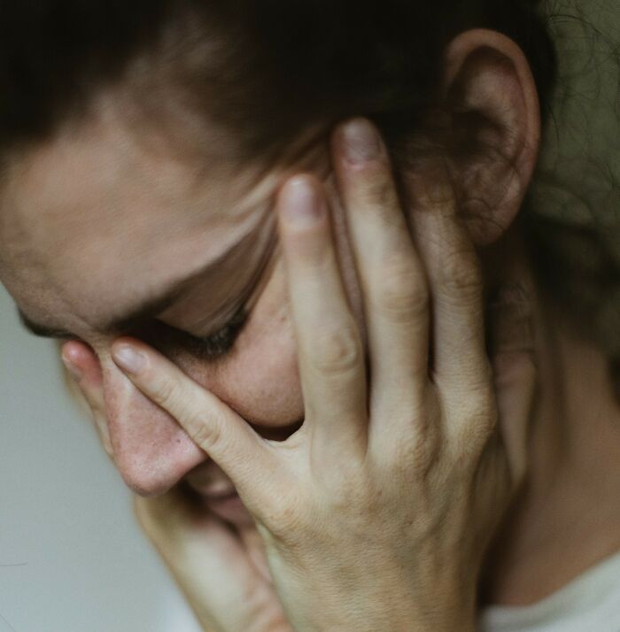 Person holding their head, possibly experiencing sudden dizziness.