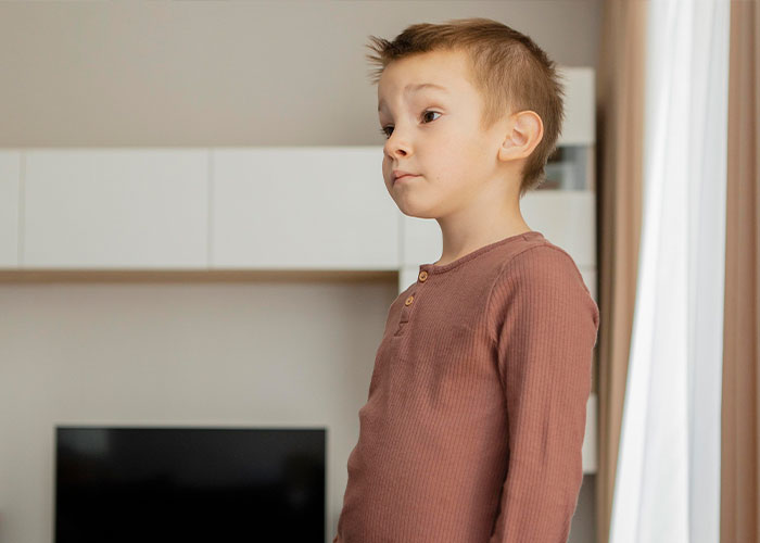 Child in a brown shirt standing indoors, reflecting memorable dad stories theme.