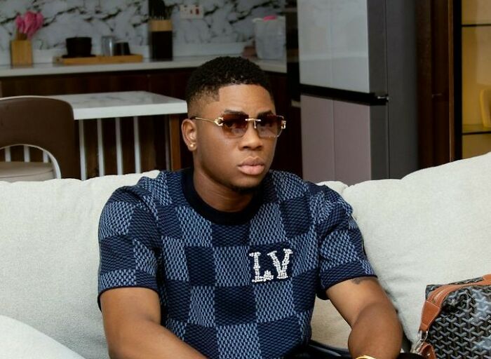 Man in sunglasses and checkered shirt on couch, illustrating a casual vibe linked to unique job interview stories.