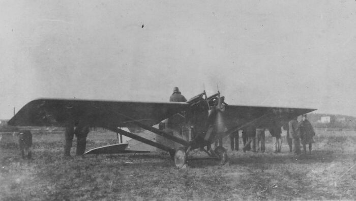Vintage airplane with people gathered around, showcasing rare photos from decades ago and highlighting changes in aviation.