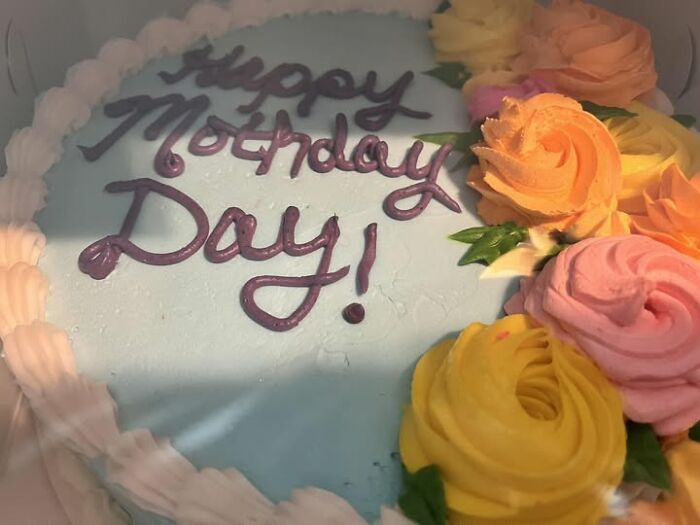 Cake with "Happy Mothday Day!" written, surrounded by colorful frosting flowers. A funny baking fail moment.