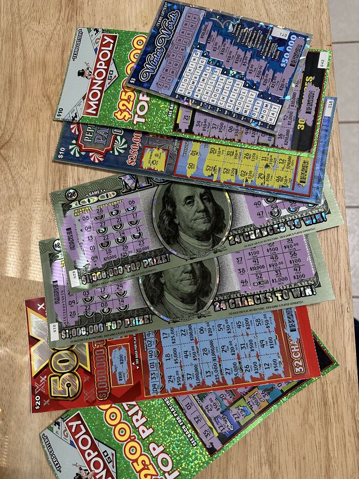 Assorted lottery tickets on a wooden table representing worst bonus received by employees.