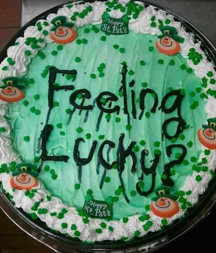 St. Patrick's Day cake fail with green icing and "Feeling Lucky?" written messily, surrounded by leprechaun decorations.