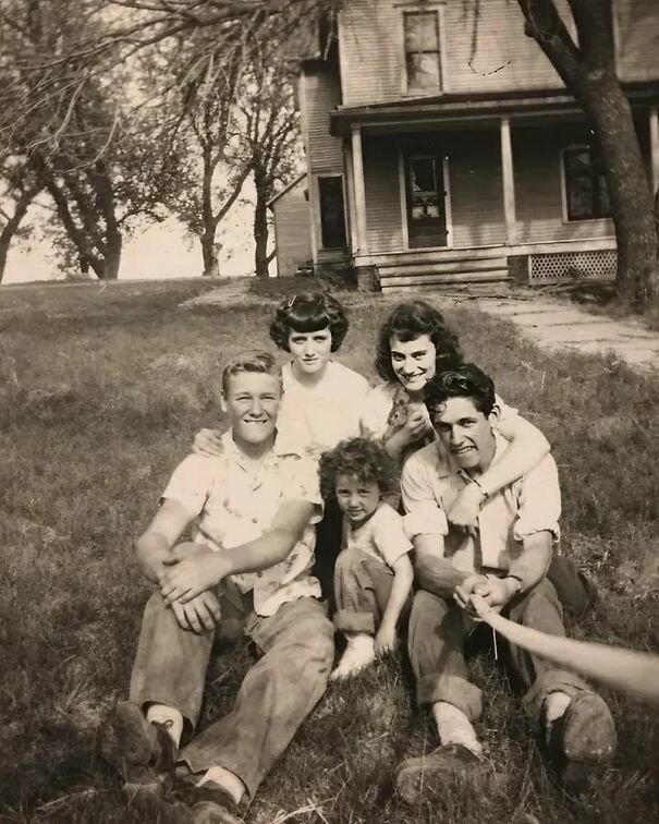 Vintage family photo in front of a house, capturing happy moments and perspectives of the past.