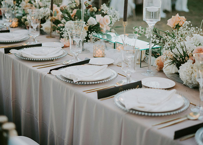 Elegant wedding table setting with floral arrangements and fine china, capturing a luxurious wedding party ambiance. Elegant wedding table setting with floral arrangements and fine china, capturing a luxurious wedding party ambiance.