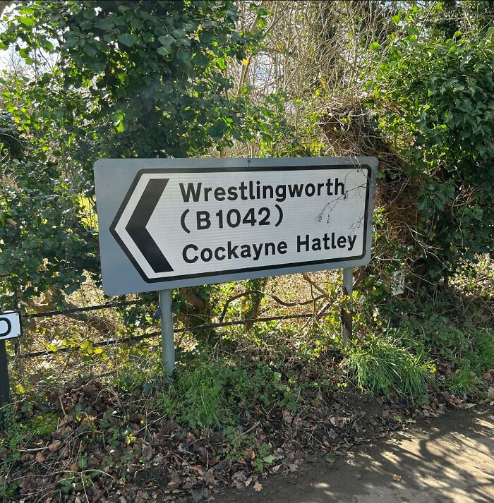 British road sign for Wrestlingworth and Cockayne Hatley, surrounded by greenery.
