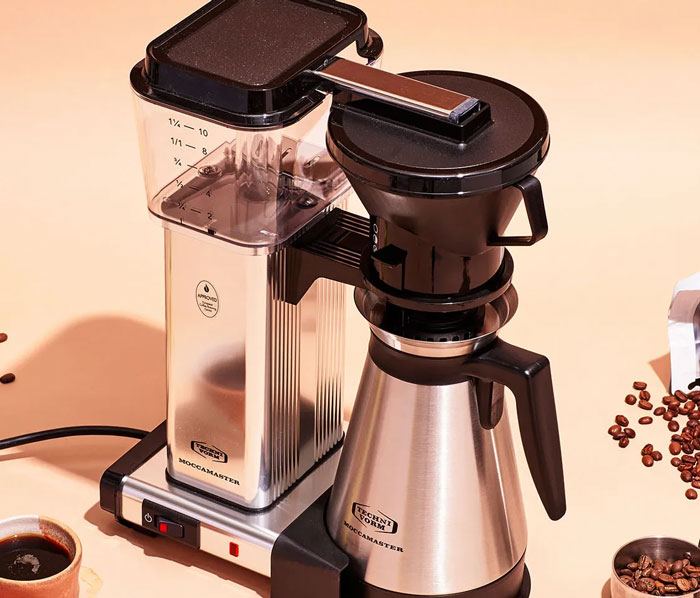 Coffee machine on a counter with scattered beans, typical appliance in American homes.