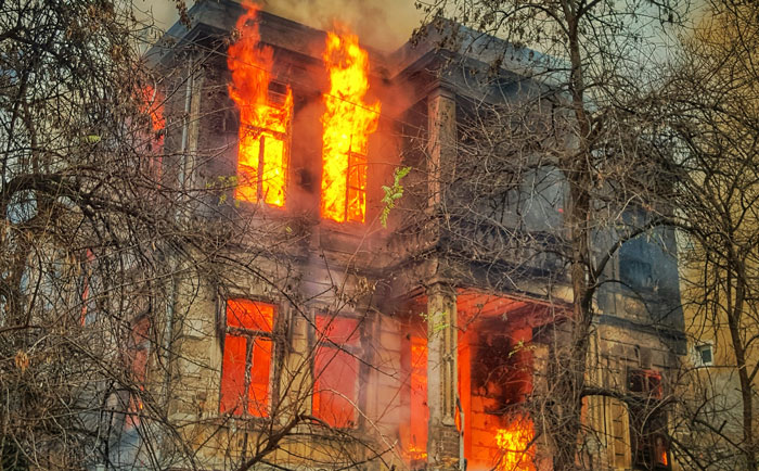 Burning building engulfed in flames, highlighting life-saving awareness and emergency preparedness.