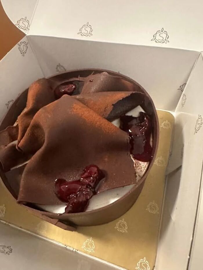 Chocolate cake baking fail with sagging layers and uneven topping, featured in a funny cake shaming group.