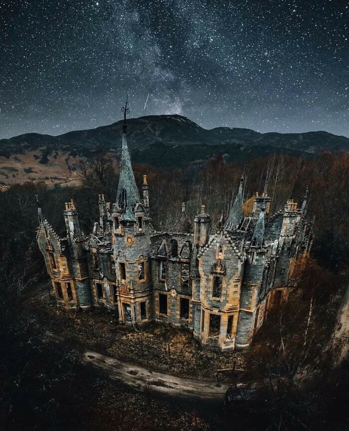Abandoned castle under a starry night sky, showcasing its haunting beauty over time.