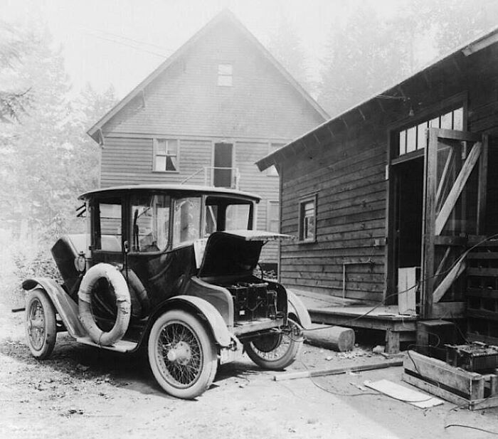 Vintage car parked beside wooden buildings, showcasing lesser-known historical moments.