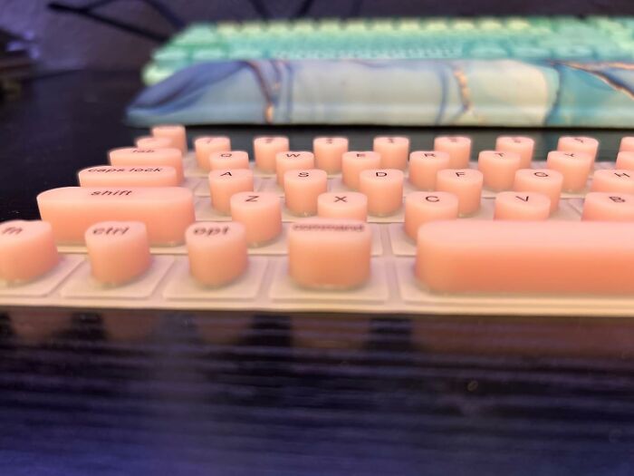 Unique perspective of pink, round keyboard keys, showcasing something extraordinary in an ordinary setting.