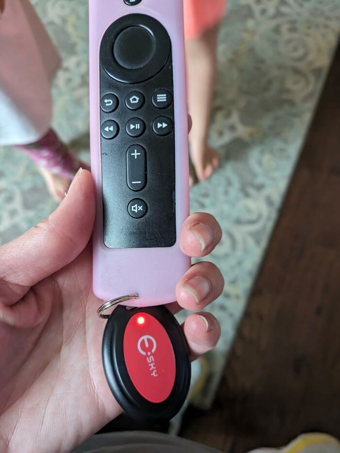 Hand holding a remote with a key finder attached, illustrating ultra-specific products' usefulness.