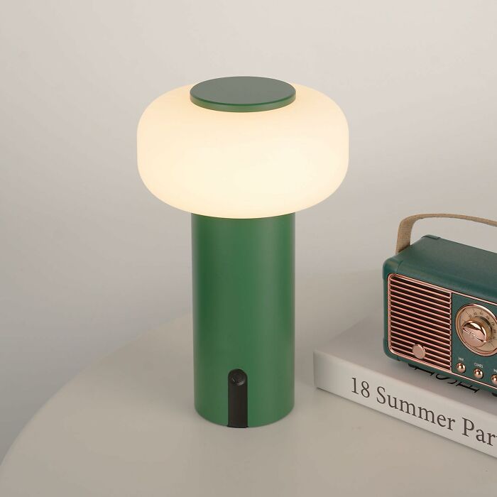 Green table lamp on a desk with a vintage radio, embodying spring finds.