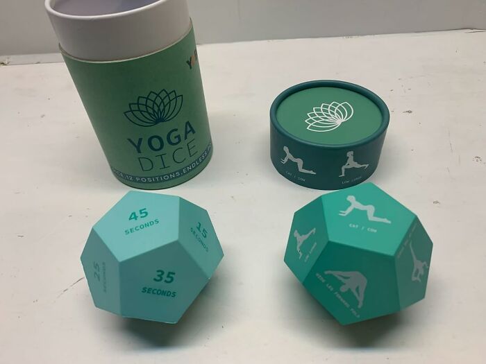 Yoga dice and boxes on a table, featuring exercise positions and timing instructions, ideal for fitness enthusiasts.