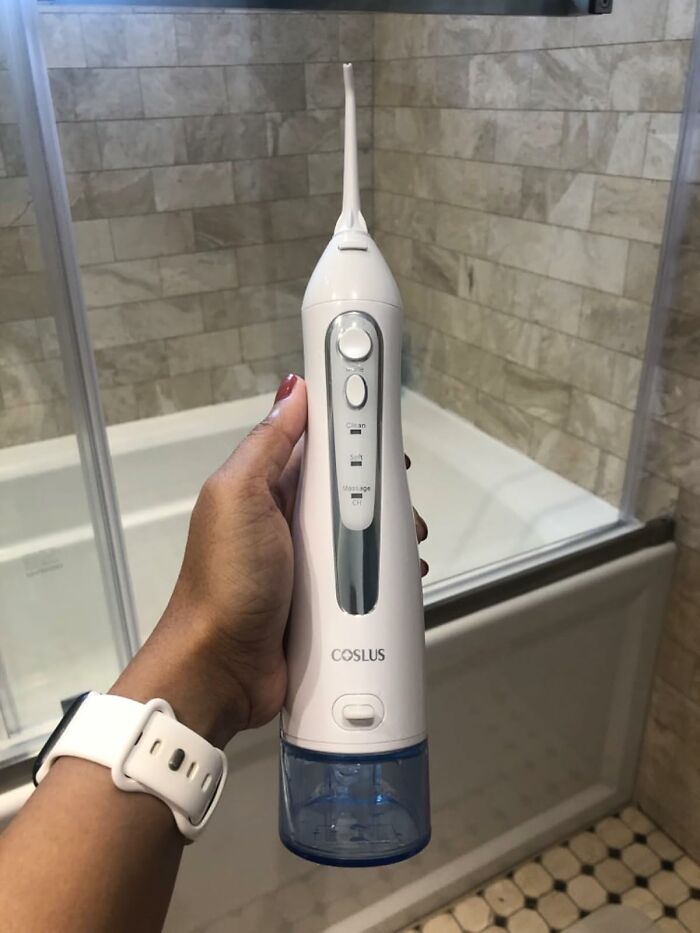 Hand holding a water flosser, showcasing a bargain spring discount available on Amazon.