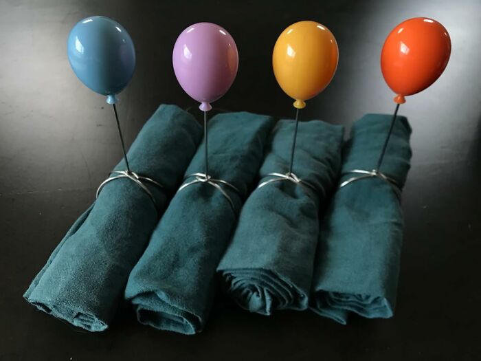 Unique napkin holders with balloon design from Peleg Design Shop on a dark background.