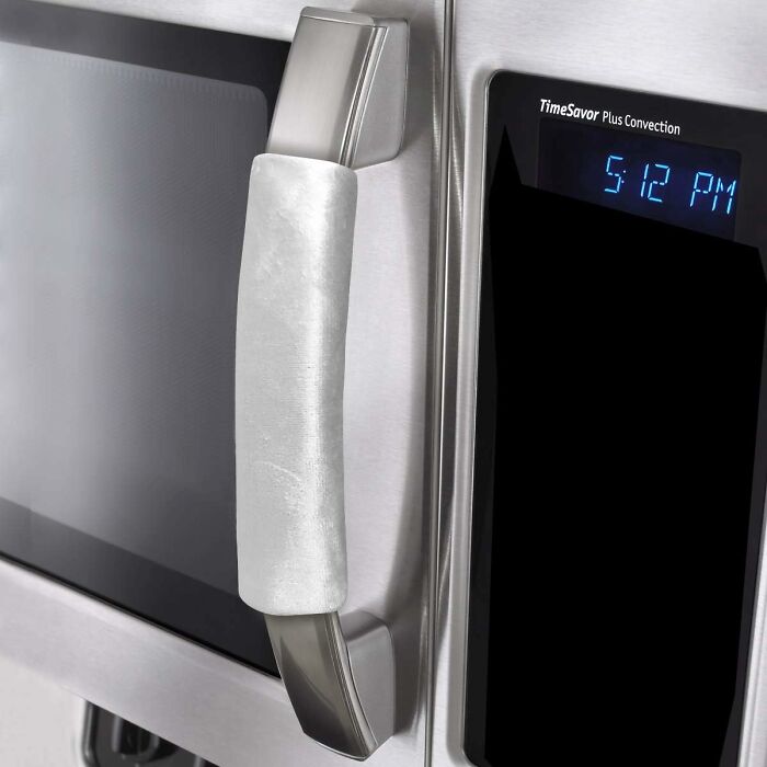 Stainless steel microwave with a digital display showing 5:12 PM.