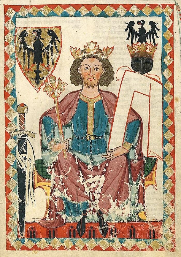 Medieval illustration of a king holding a scepter, with heraldic symbols on a shield, from a cool Wikipedia article.