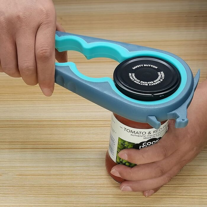 Person using a jar opener to solve kitchen problem with ease on a wooden table.