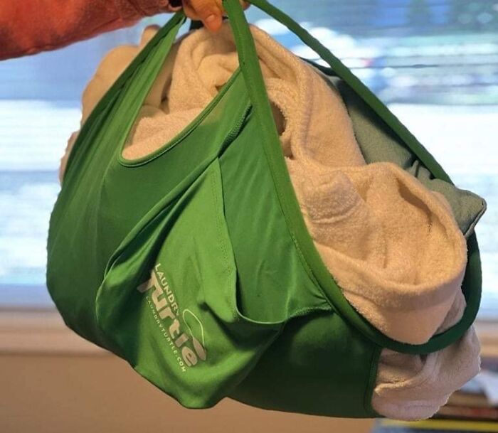 A green laundry bag holds towels, showcasing an extraordinary everyday item with practical design.