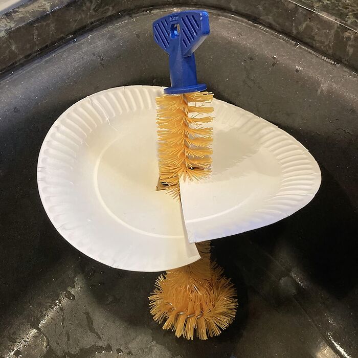 Cleaning brush trapped in paper plates over a sink, highlighting sneaky spots that challenge how clean your home is.