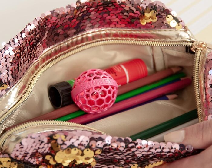 Sequin pouch with pencils and a pink ball.
