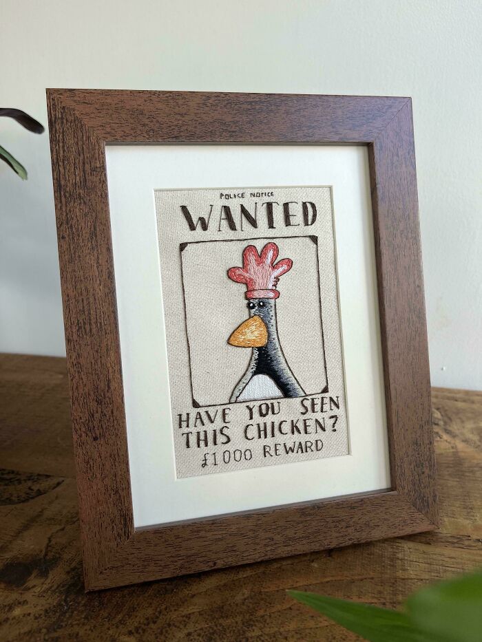 Framed embroidery of a wanted poster featuring a cartoon chicken with intricate and beautiful embroidery skills.