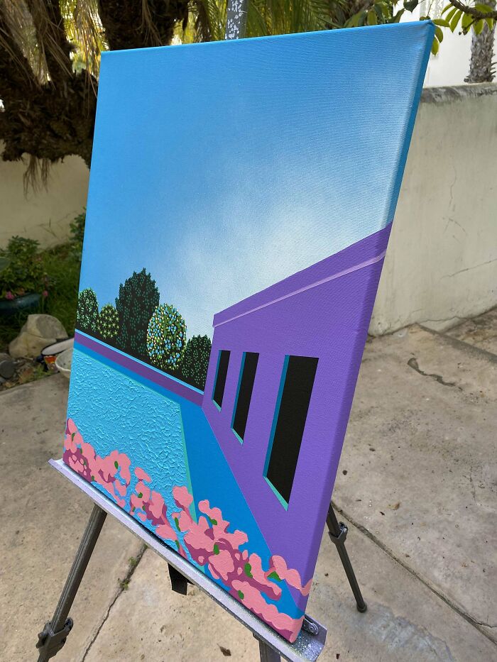 Colorful DIY project painting on an easel, featuring a vibrant landscape with a purple house and pool.
