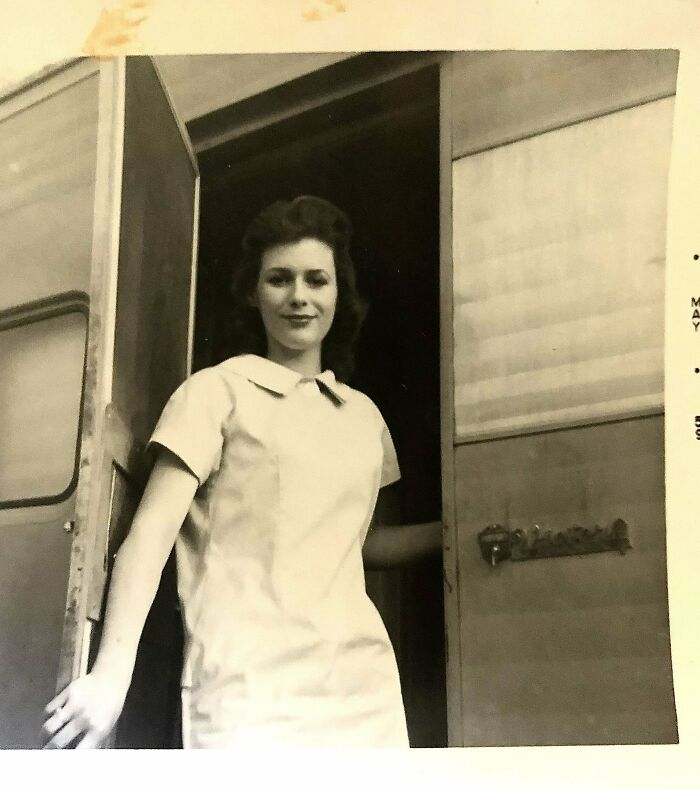 Young woman standing in a doorway, captured in a candid glimpse into the past showing everyday moments not in history books.