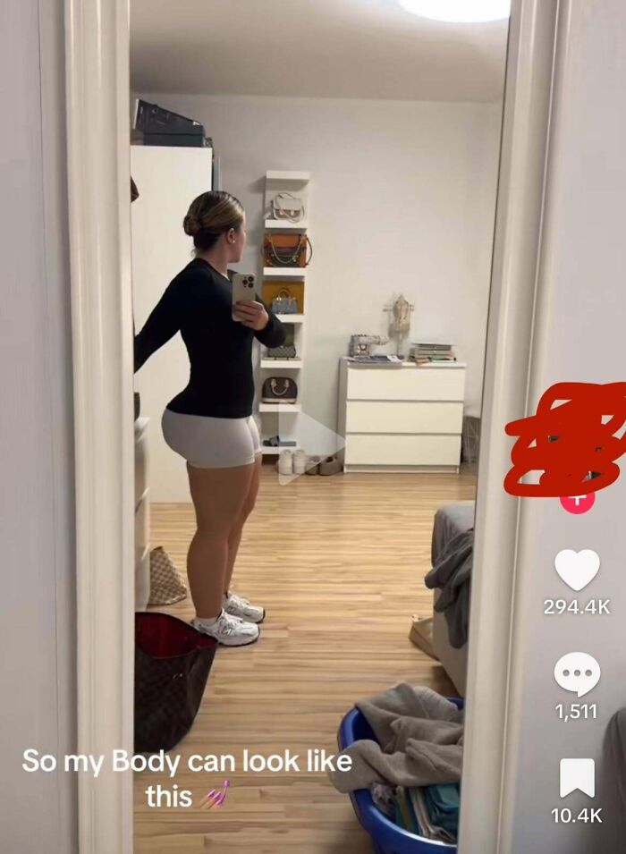Mirror selfie showing a woman in white shorts and black top, with text overlay about body appearance.