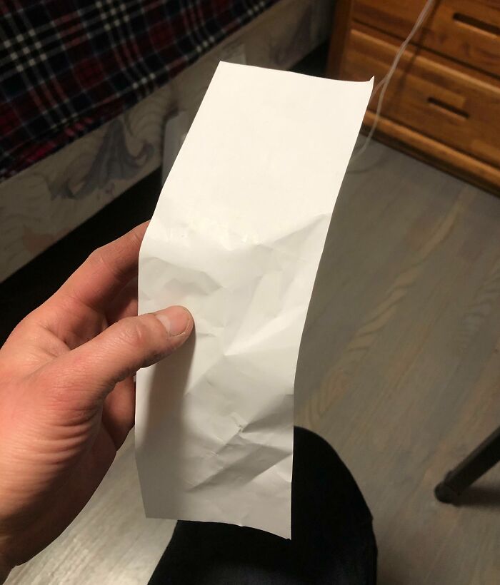 A crumpled receipt being held, showcasing an interesting find.