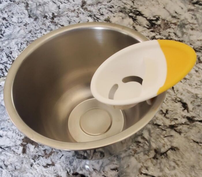 Cheap fix: egg separator placed on a metal bowl for easy egg yolk and white separation.
