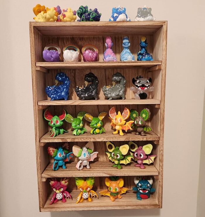 Wooden shelf displaying colorful collectible figures, ideal for organizing sentimental clutter.