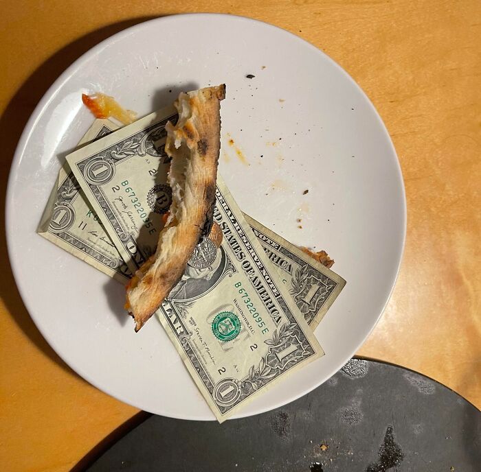 Plate with a pizza crust and dollar bills, illustrating mildly infuriating server tips.